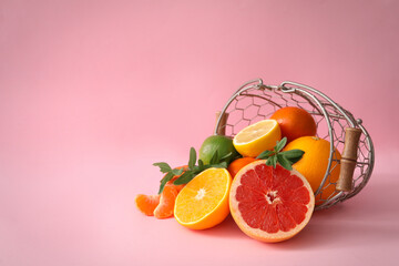 Assortment of exotic fruits in basket on pink background. Space for text