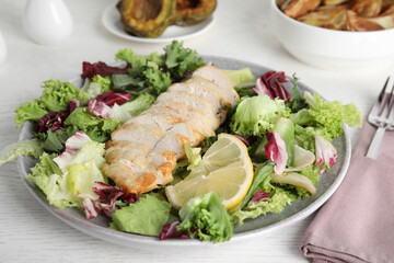 Tasty cooked chicken fillet with fresh salad served on white wooden table. Healthy meals from air fryer