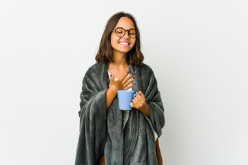 Young latin woman with blanket isolated on white background