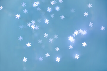 Naklejka na ściany i meble Beautiful snowflake shaped lights on light blue background
