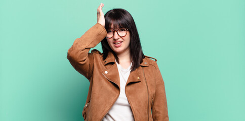plus size pretty woman raising palm to forehead thinking oops, after making a stupid mistake or...