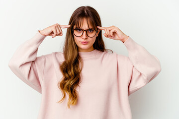 Young caucasian cute woman isolated on white background focused on a task, keeping forefingers pointing head.