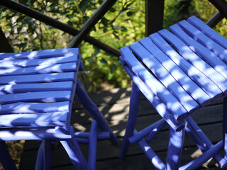 Bright blue pair of wood bar stools on balcony