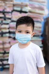 Portrait of little Asian boy wearing mask for protect pm2.5 pollution and coronavirus