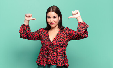 young pretty casual woman feeling proud, arrogant and confident, looking satisfied and successful,...