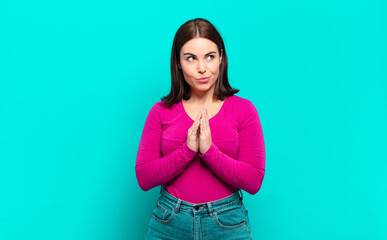 young pretty casual woman feeling proud, mischievous and arrogant while scheming an evil plan or...