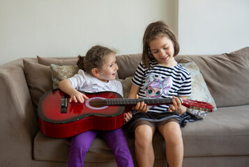 little sisters playing guitar.  © Yasin