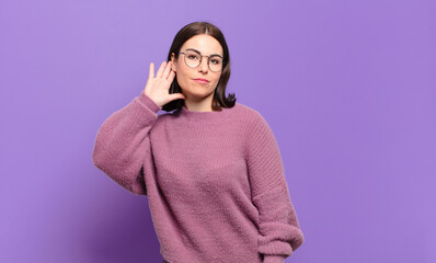 young pretty casual woman looking serious and curious, listening, trying to hear a secret...
