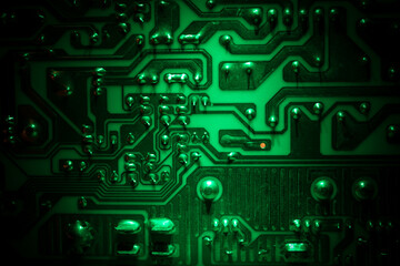 Stylized photo of an electronic microcircuit. Microcircuit, contacts, electronics, motherboard. Black background. Macro photography of electronic devices.