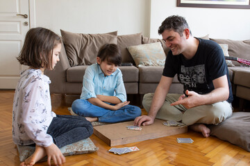 Fototapeta premium dad and kids playing and learning card games. 