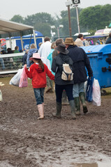 Family at country fair walking through mud