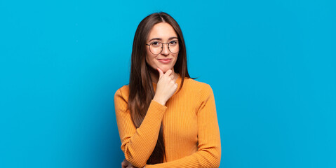 young pretty casual woman looking serious, confused, uncertain and thoughtful, doubting among...