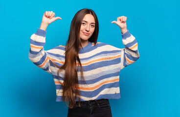 young pretty casual woman feeling proud, arrogant and confident, looking satisfied and successful,...