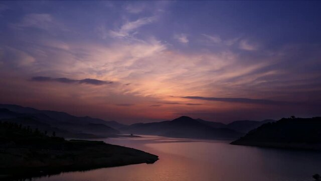 Time-lapse of sunrise scenery, silhouettes of river and mountain