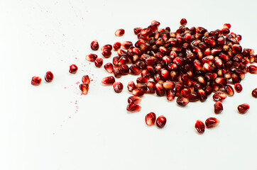 peeled pomegranate closeup seeds isolated on white background
