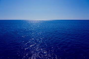 The sea goes beyond the horizon with a blue sky in the background.