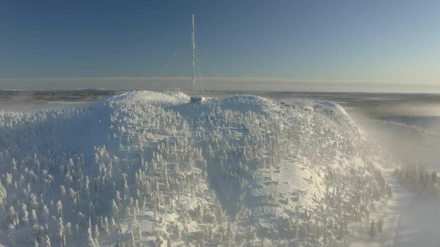Winter ski resort on Rukatunturi hill in Kuusamo, Lapland, Finland, aerial drone shot