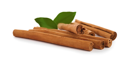 Aromatic dry cinnamon sticks and green leaves on white background