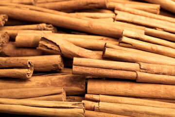 Aromatic dry cinnamon sticks as background, closeup