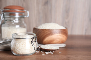 Uncooked rice on wooden table, space for text