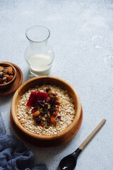 a bowl of oats with nuts and dried fruits in white background