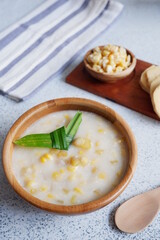  corn and sweet potato soup  in a wooden bowl in white background 