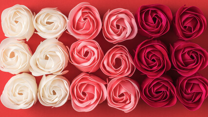 Background of artificial rose buds of three colors.