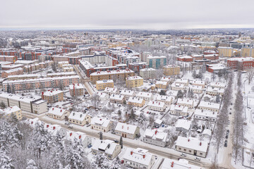 Lahti, Finland February 14, 2021. Photo from the drone. City view, residential buildings and streets covered in snow, partly forested area. The day is cloudy, winter