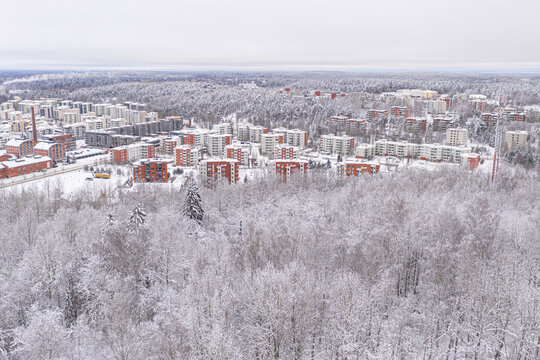 Lahti, Finland February 14, 2021. Photo from the drone. City view, residential buildings and streets covered in snow, partly forested area. The day is cloudy, winter