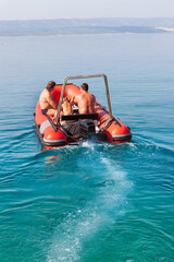 an inflatable boat with a motor sailing away on the sea