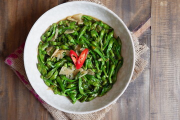 a plate of sauteed limnocharis flower or sawah-lettuce flower on the table  