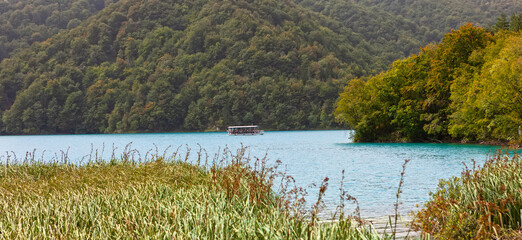 A pleasure boat sails on the turquoise waters of the Plitvice Lakes.Croatia