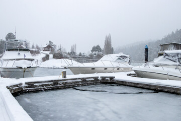 Boat covered in snow at a marina on Vancouver Island, British Columbia, Canada