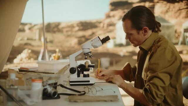 Archaeological Digging Site: Great Male Archaeologist Doing Cultural Research, Discovers Ancient Civilization Historical Artifacts, Fossil Remains at Excavation Site, Study it Under Microscope