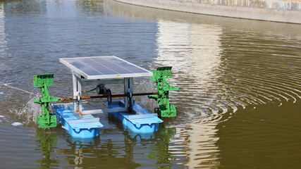 Fototapeta na wymiar Paddle Wheel Solar Cell. Hydraulic turbine of pond wastewater treatment system for producing oxygen in water using solar power with copy area. Selective focus