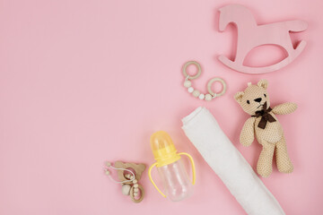 Cute wooden baby toys on light-blue background. Knitted bear, rainbow, dinosaur toy, beads and stars. Eco accessories, beanbag and teethers for newborn. Flat lay, top view