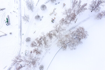 Fototapeta premium winter park landscape. empty playground covered with snow. top view aerial photo from flying drone