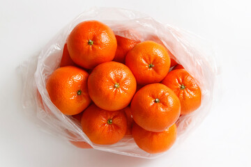 mandarin, tangerine citrus fruit in a polybag on white background. vertical