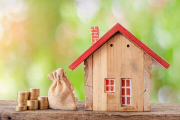 Money coin stack with wooden house.Property investment and house mortgage financial concept