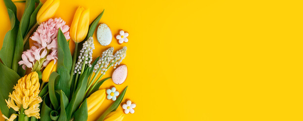 Easter floral background, various gingerbread glazed cookies end decorated with natural botanical elements on yellow, flat lay, view from above, blank space for greeting text, banner, flyer, coupon