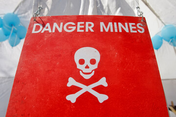 Danger mines and skull with bones, red sign on white background