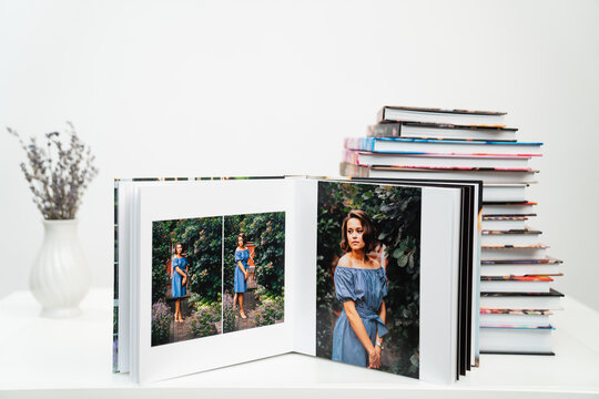 stack of books. open photobook from photo shoots of a beautiful happy woman