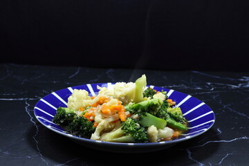 Traditional fried and stirred fresh vegetable with soy sauce and pepper serving on the plate. Famous vegetarian menu in Asia restaurant.  