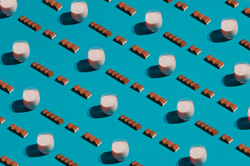 Modern food pattern of chocolate bars and milk on a blue background