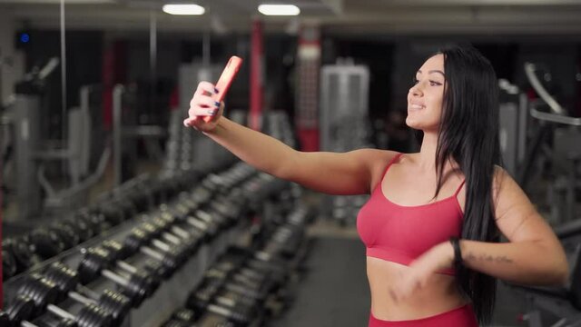 sexy girl taking a selfie on the phone in the gym