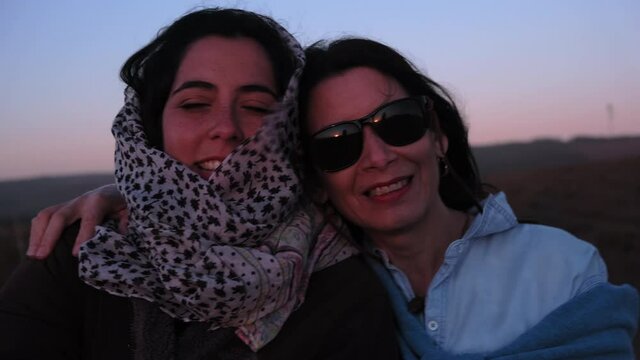 mother and adult daughter sunset close up smiling