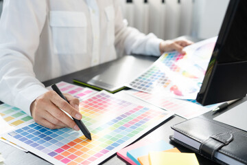 interior designer or creative graphic designer working on project architectural with colour samples with work tools and equipment for selection in office