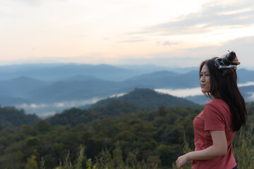 Naklejka na ściany i meble Happy Asian woman in red shirt traveler with camera at the view point for sunrise. Travel Lifestyle adventure concept