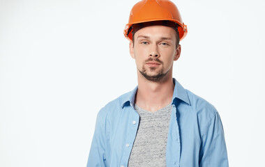 male architect in orange hard hat working gray background cropped view
