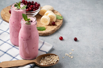 Homemade yogurt smoothie with banana, cranberry and oatmeal, copy space